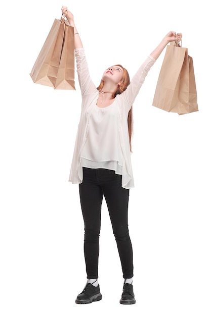 Encantadora joven riéndose después de ir de compras sosteniendo bolsas de papel de su tienda favorita. Concepto de compra feliz