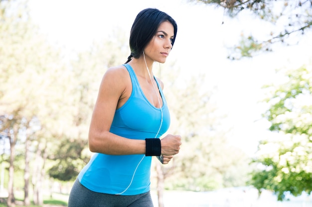 Encantadora mujer deportiva corriendo en el parque