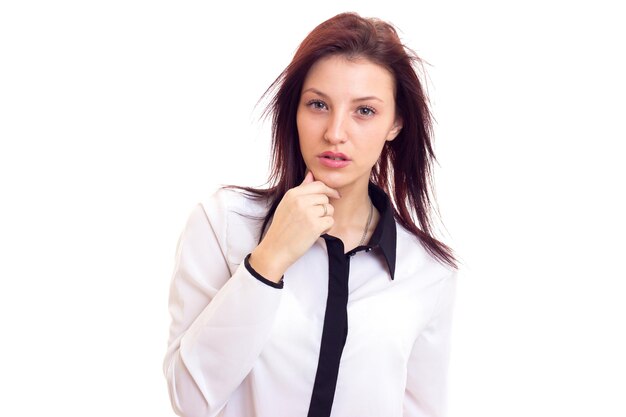 Encantadora mujer joven en camisa blanca y negra con cabello oscuro sobre fondo blanco en estudio