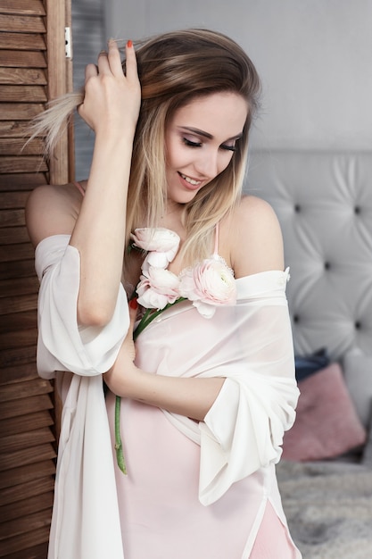 Encantadora mujer joven con flores en sus manos