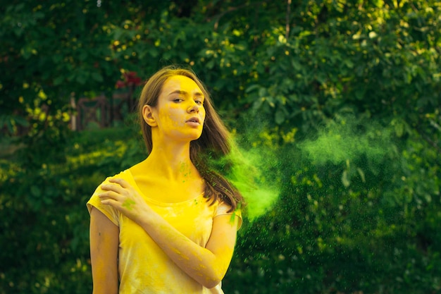 Foto encantadora mujer morena con holi en polvo en la cara