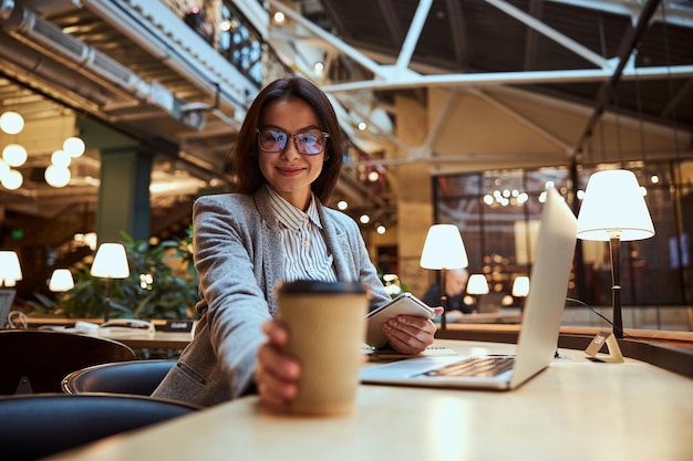 Encantadora mujer morena tomando su café aromático