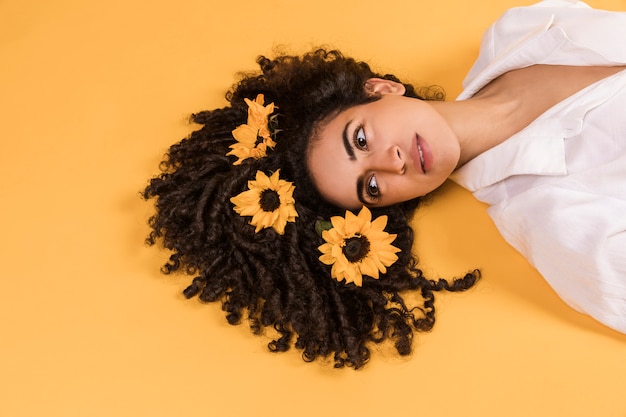 Foto encantadora mujer pensativa con flores en el pelo