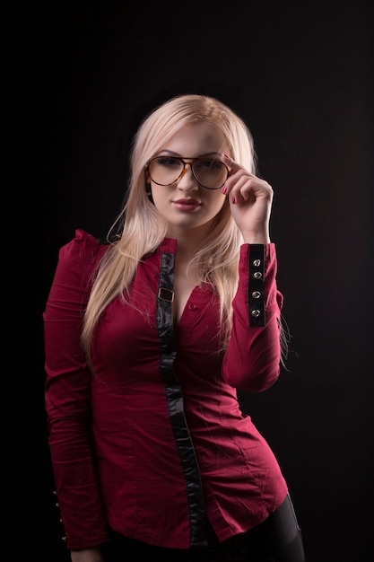 Encantadora mujer rubia con gafas y vestida con blusa roja