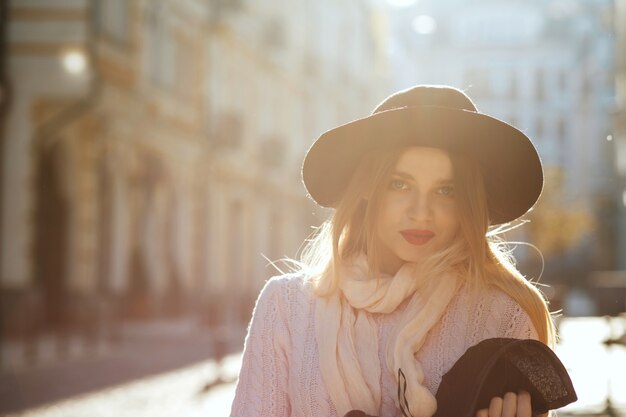 Encantadora mujer rubia vestida con suéter y sombrero. Espacio para texto