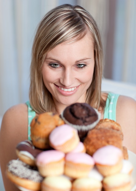 Encantadora mujer sosteniendo un plato de pasteles