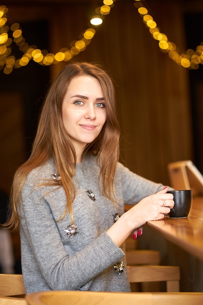 Encantadora mulher jovem e atraente com cabelos longos, maquiagem natural e sorriso amigável