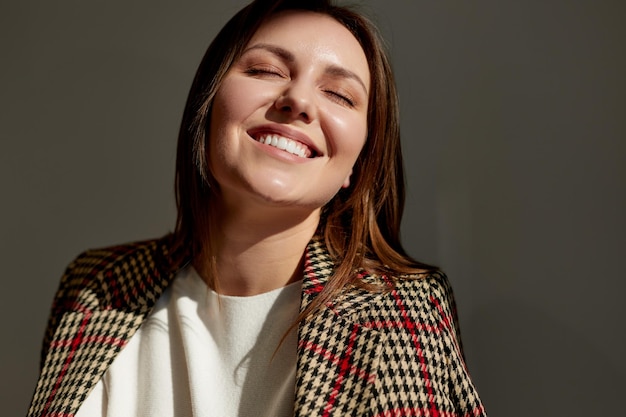 Encantadora mulher sorridente, aproveitando o sol da manhã