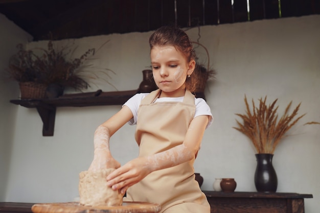 Encantadora niña artesana disfrutando del arte de la cerámica y producti