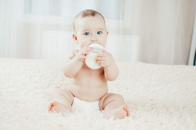 Encantadora niña comiendo solo mezcla, leche, papilla sentada