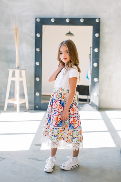 La encantadora niña posando en un hermoso vestido azul.