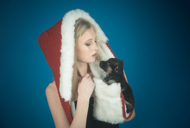 Encantadora niña con sombrero de Santa Claus con cachorro Feliz Navidad y Próspero Año Nuevo