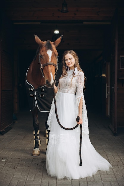 Encantadora noiva em estilo boho em um rancho com um cavalo