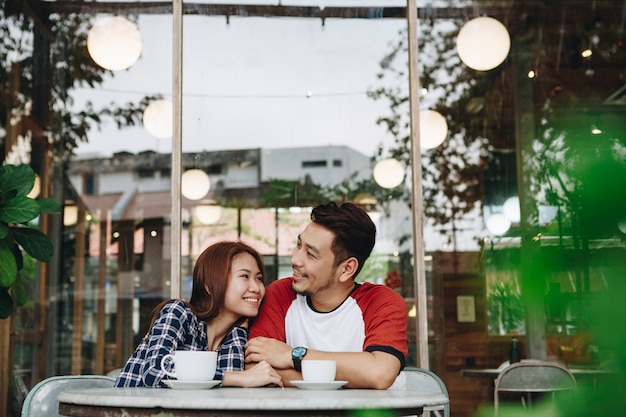 Encantadora pareja asiática tomando un café