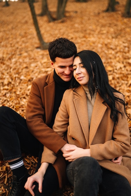 Encantadora pareja caminando en el bosque de otoño