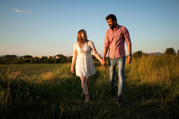 Encantadora pareja caminando en el campo de verano