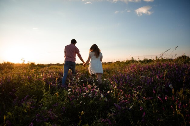 Encantadora pareja caminando en el campo de verano