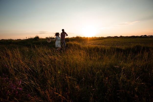 Encantadora pareja caminando en el campo de verano