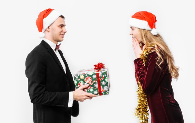 Encantadora pareja dando regalos de Navidad