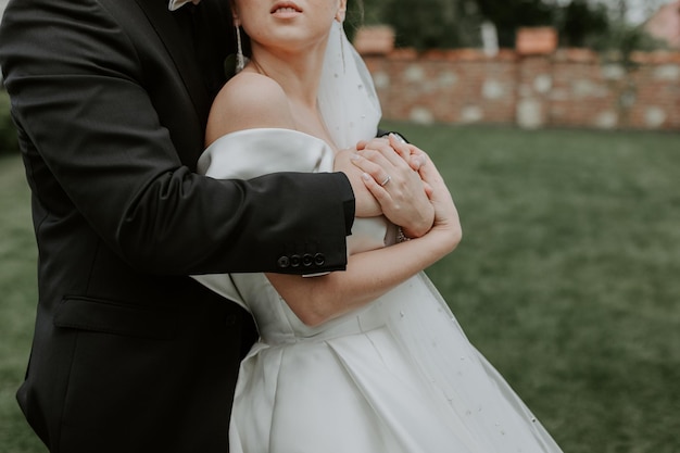 La encantadora pareja enamorada abrazándose y de pie en el parque