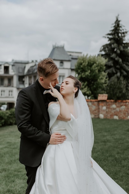 La encantadora pareja enamorada abrazándose y de pie en el parque