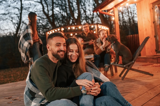 Encantadora pareja Grupo de personas pasa tiempo juntos en el patio trasero por la noche