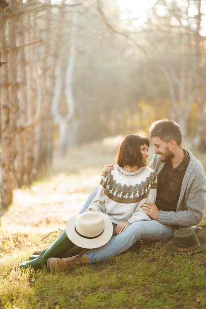 Encantadora pareja hipster mirándose Pareja con hermosos sombreros y suéteres