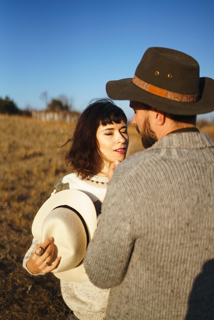 Encantadora pareja hipster mirándose Pareja con hermosos sombreros y suéteres