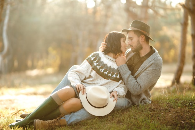 Encantadora pareja hipster mirándose Pareja con hermosos sombreros y suéteres