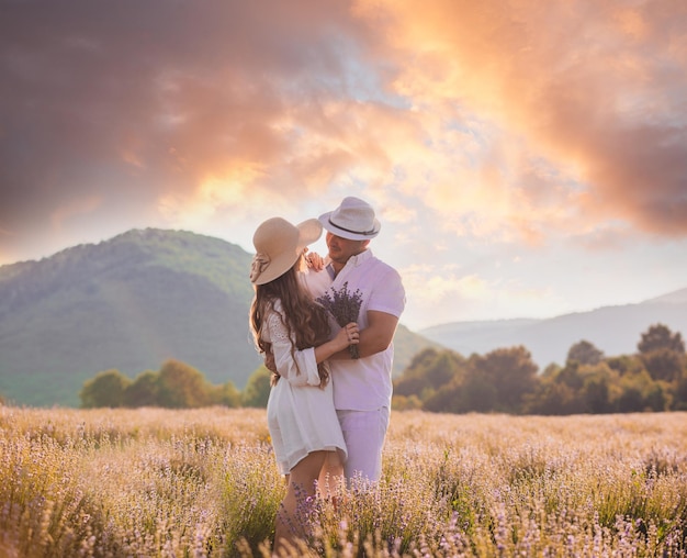 Encantadora pareja joven abrazándose en el campo de lavanda