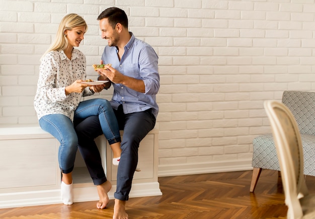 Encantadora pareja joven comiendo pizza