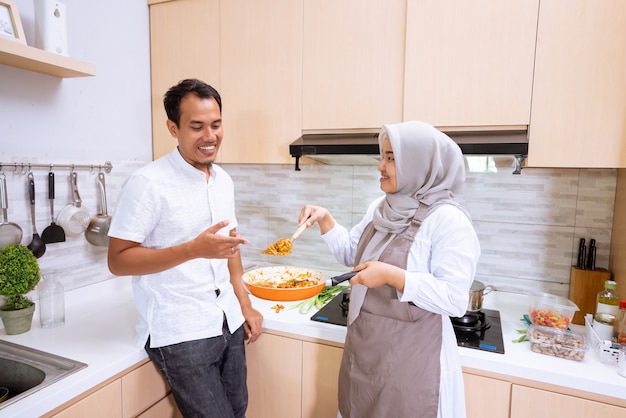 Encantadora pareja musulmana asiática disfruta de cocinar juntos en la cocina