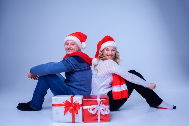 Encantadora pareja de navidad sentada con regalos