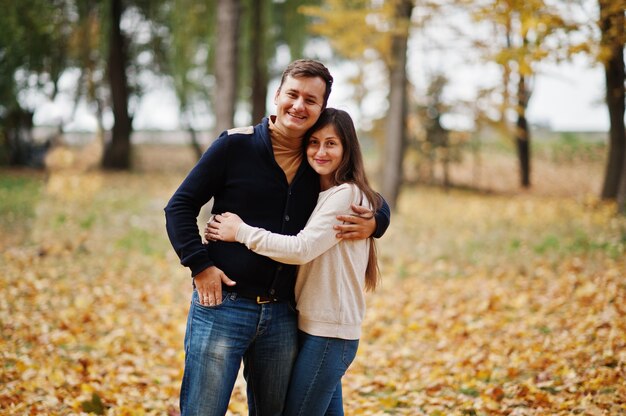 Encantadora pareja en el parque de hojas de otoño.