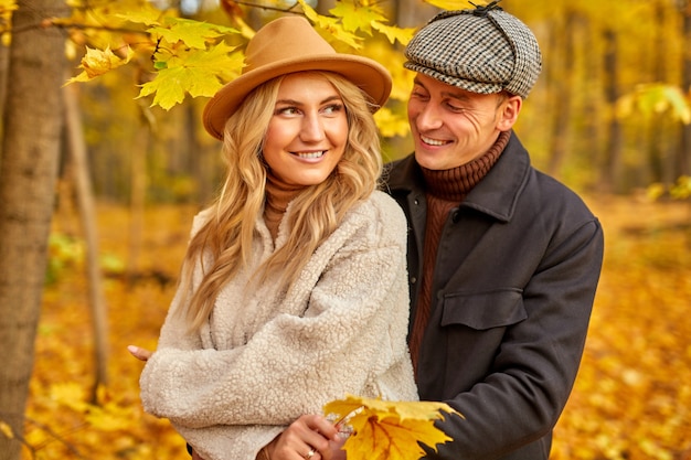 Encantadora pareja posando en el bosque de otoño