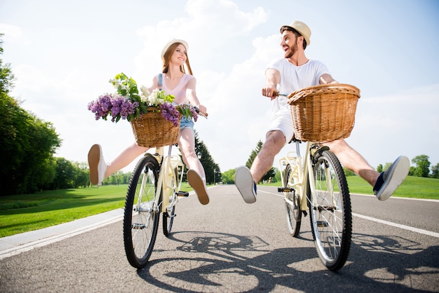 Encantadora pareja posando juntos al aire libre con bicicletas