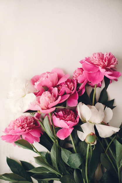 Encantadoras peonías rosadas sobre fondo de madera blanco rústico vista superior espacio para texto tarjeta de felicitación floral endecha plana hermoso patrón de flores de peonía imagen tierna concepto de feliz día de las madres