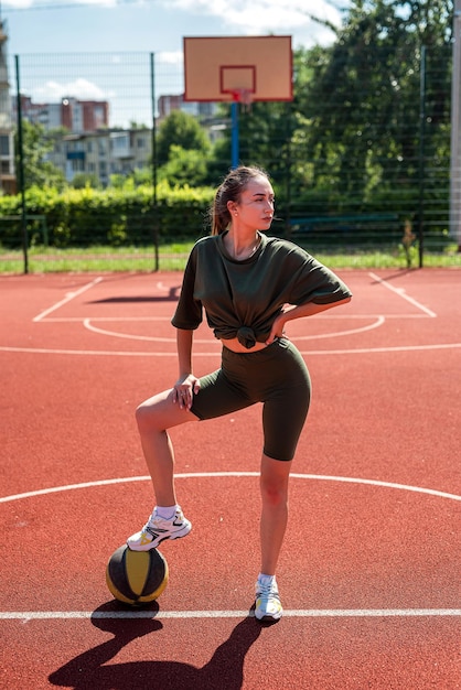 Encanto mujer joven con baloncesto en el patio de deportes