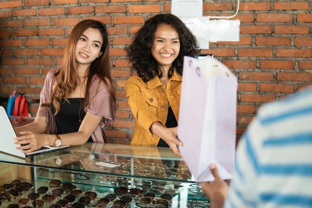 encargado de la tienda dando bolsa de compras