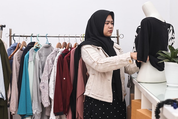 encargado de la tienda de diseñadores musulmanes asiáticos trabajando en su tienda de ropa