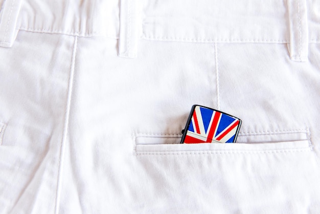 Encendedor con la bandera británica en el bolsillo de los jeans blancos