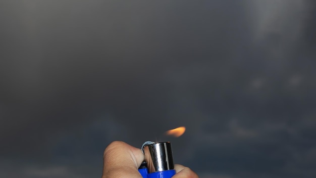 Encendedor encendido en la mano en el cielo nocturno