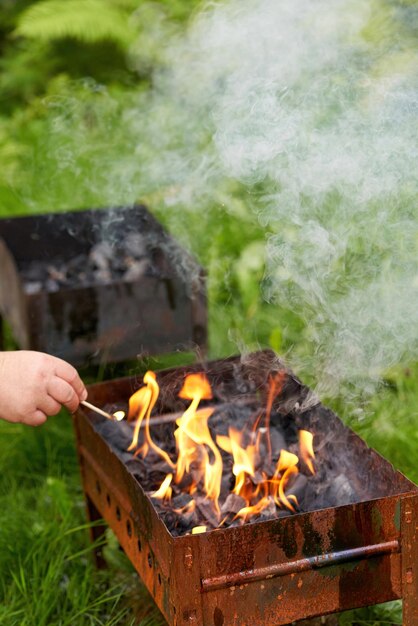 Encender una vieja parrilla de barbacoa de metal oxidado humo y fuego