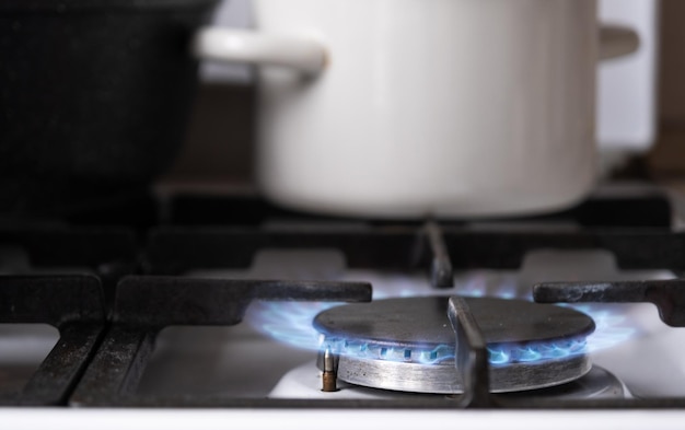 Encendido del quemador de gas en la estufa de la cocina Uso de la economía de los recursos naturales cocinar al fuego Primer plano