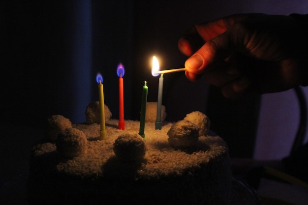 Foto encendiendo cuatro velas en un pastel de cumpleaños