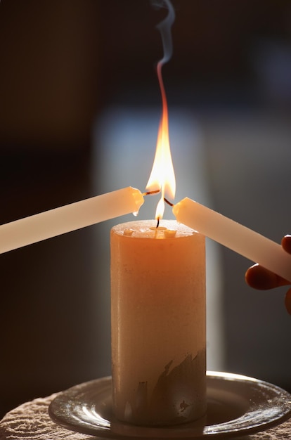 Encendiendo su llama eterna Primer plano recortado de una pareja encendiendo velas durante su ceremonia de boda