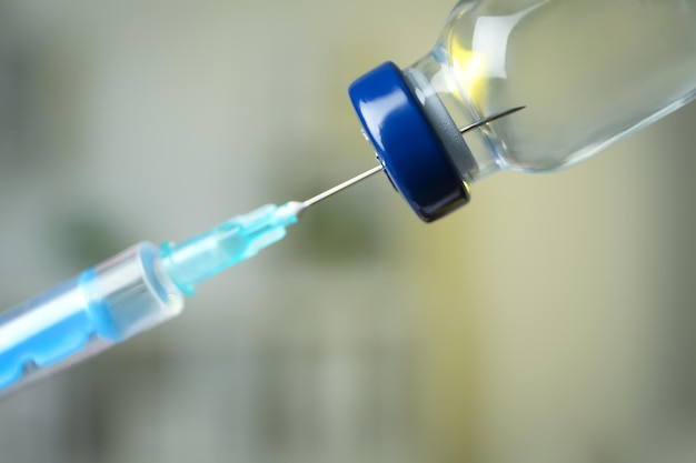 Enchendo a seringa com medicação do frasco contra fundo desfocado closeup Vacinação e imunização