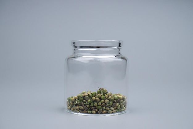 Enchendo um recipiente de vidro com sementes de cannabis cultivo de cannabis cultivar sementes de cânhamo