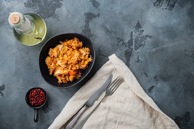 Enchilada de frango de uma panela, caçarola de arroz, em fundo cinza, vista de cima plana com espaço de cópia para o texto