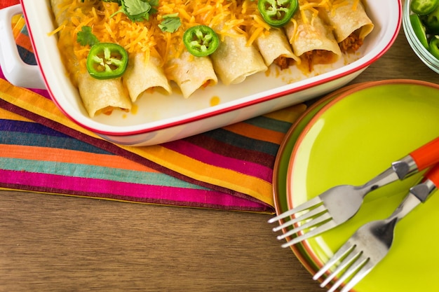 Enchiladas de frango com queijo cheddar e molho.